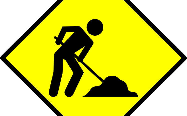 Yelow sign with man shoveling